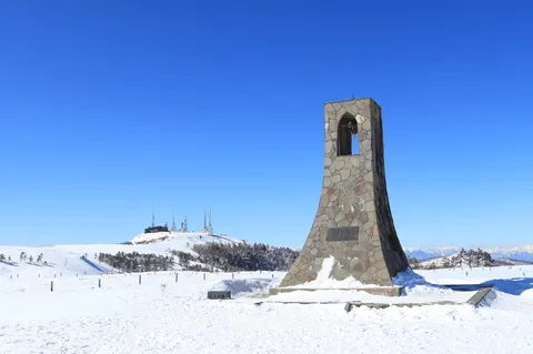 青空の下に立つ雪の石塔