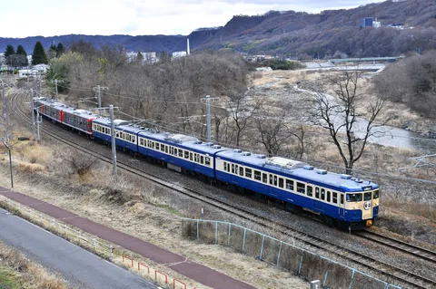 川沿いを走る青い列車