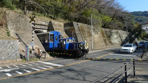 青い列車と踏切の静かな風景