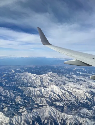 雪化粧の山脈と飛行機の翼