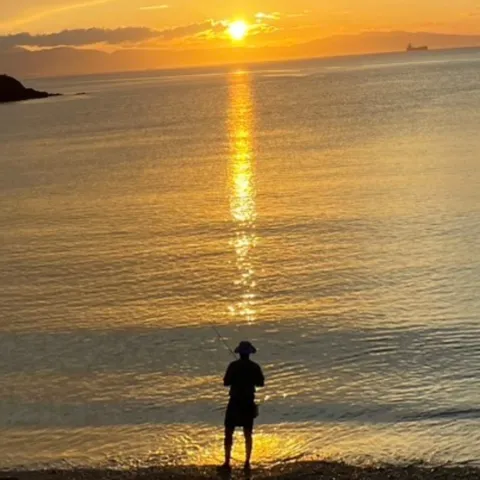 夕陽に照らされる一人の釣り人