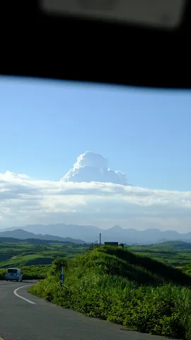 雄大な雲と緑の丘、風の道