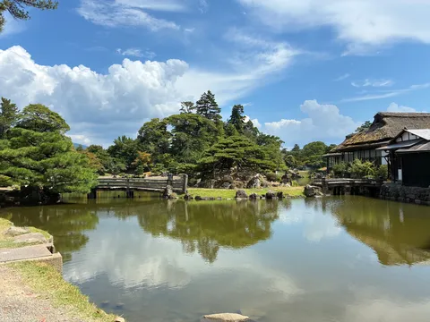 静寂の水面と茅葺の家
