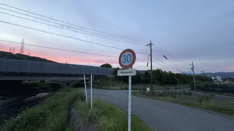 夕焼け空の下、道と標識