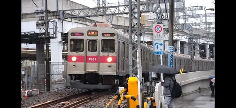 雨のホームへ滑り込む急行列車
