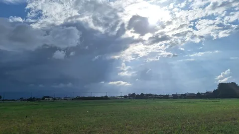 雲間の光が刺す田園