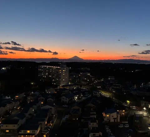 夕暮れの街景と山影
