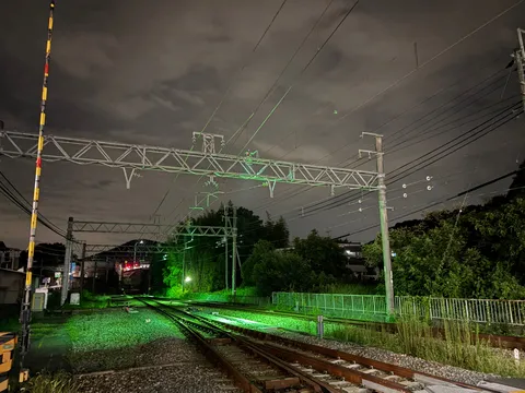 夜の線路に灯る緑の光