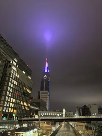 都会の夜空に放つ、神秘的な光の柱