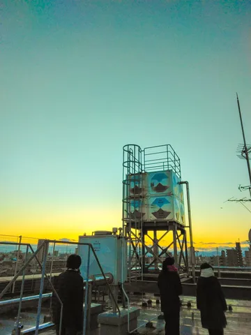 夕焼けと水塔、都会の孤独