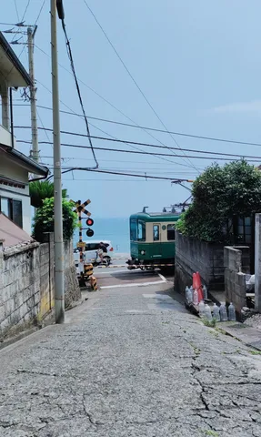 海辺の踏切、電車と青い海