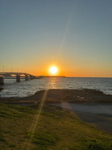 夕陽に照らされる、静かな海辺の道