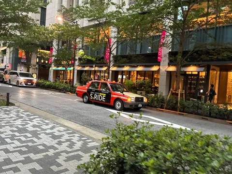 都会の道を行く赤いタクシー