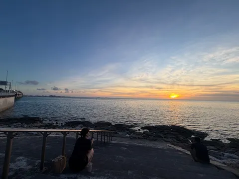 水平線に沈む太陽と二人のシルエット