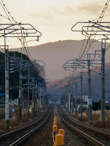 夕暮れの鉄路、光の糸