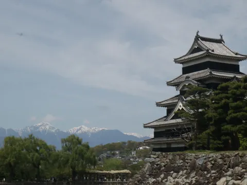 悠久の時を映す古城と雪化粧の山
