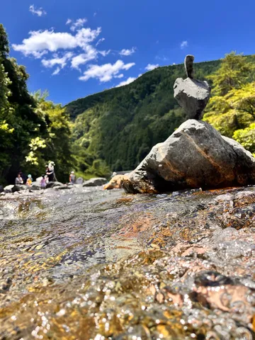 清流に佇む石と夏空