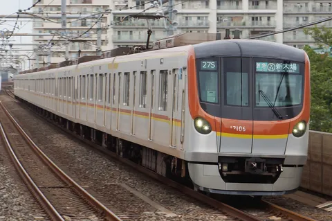 架線を抜けるオレンジの列車