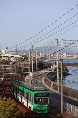 海沿いの緑の電車、電線がアート