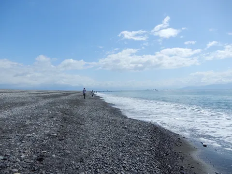 広がる小石浜と人影