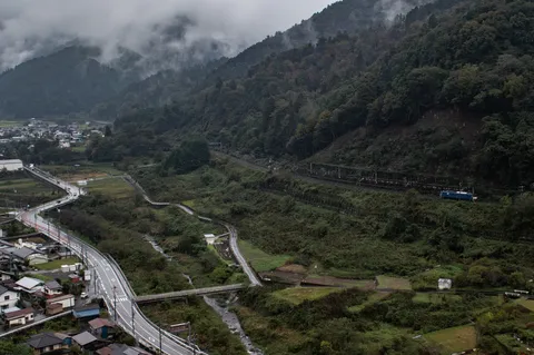 雨に煙る山間の列車