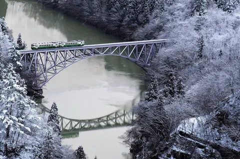 雪景色を渡る緑の列車