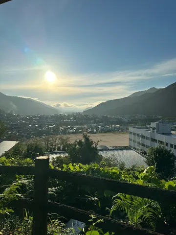 山間に昇る朝日と町並み