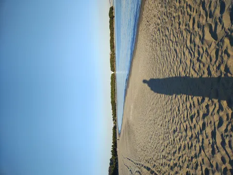 砂浜に伸びる影と青い海
