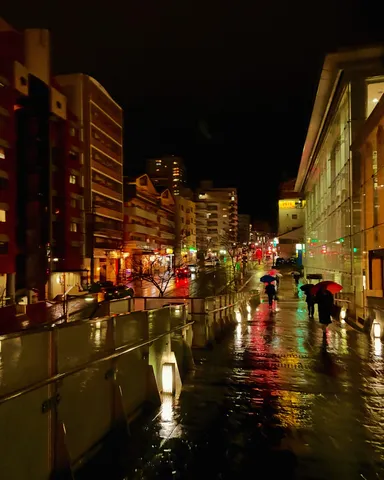 雨の夜、傘の花が咲く街
