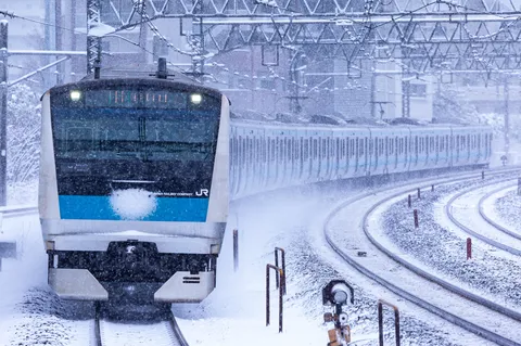 吹雪を切り裂く通勤列車