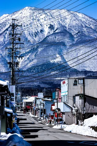 雪山の麓、電線が織りなす冬景色