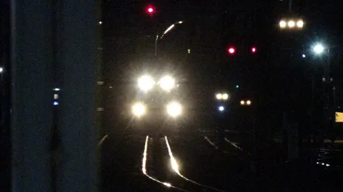 夜の線路、ヘッドライトの輝き