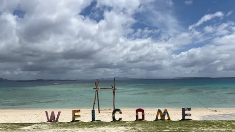 砂浜に並ぶWELCOMEの風景