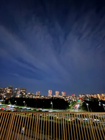 都会の夜景と流れる雲