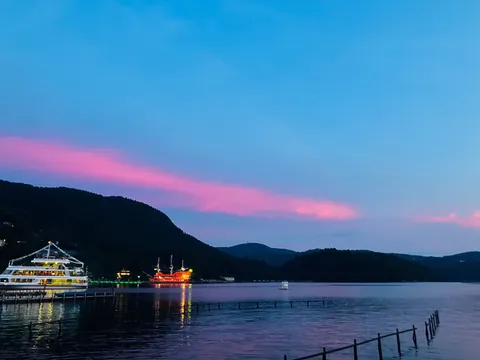 夜に浮かぶ光の船と薄紅の空