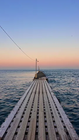 どこまでも続く桟橋、青とオレンジの空