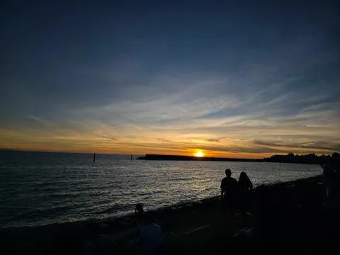 夕暮れ時の海岸、二人のシルエット