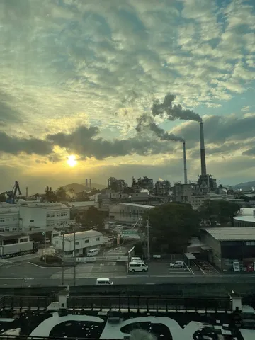 夕陽に煙る工業地帯の朝