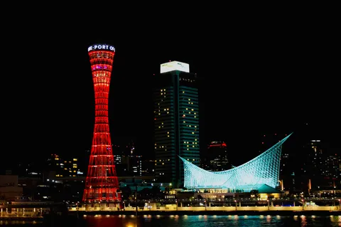 夜景に浮かぶ灯台と未来的な建物