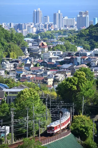 緑と街を駆け抜ける赤い列車