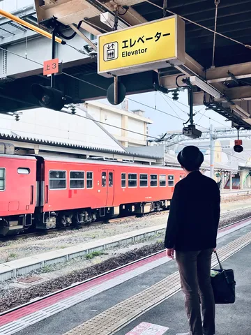 「エレベーター」の標識と赤い列車