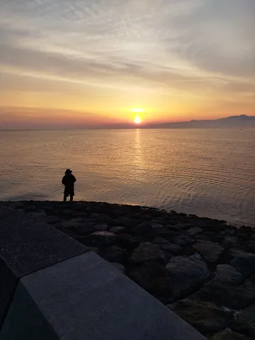 水面に輝く夕陽とシルエット