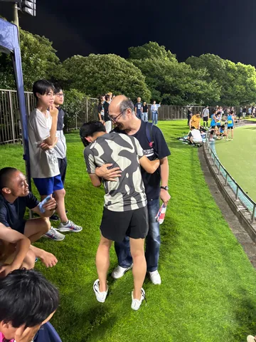 夜のグラウンドに抱き合う二人