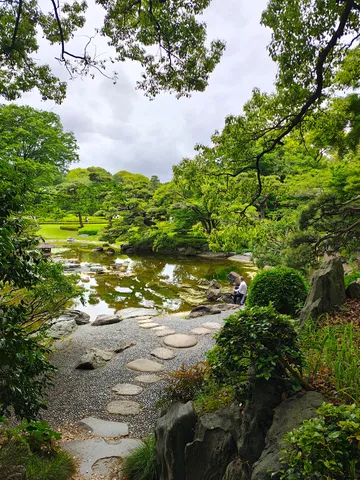 水面に映る、庭園の緑と小径