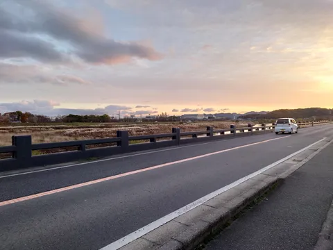 夕焼けと車、穏やかな橋の上