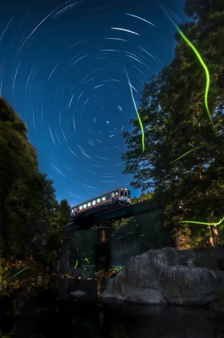 夜空を駆ける列車と光の妖精たち