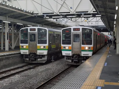 並ぶJR車両と朝の駅風景