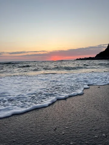 水平線に沈む夕陽と波打ち際