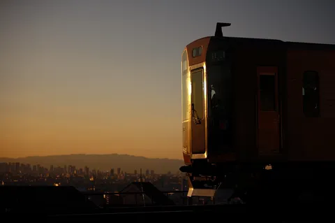 夕陽に照らされる電車の旅路