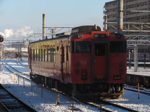 雪景色の中の赤い列車、旅情を誘う。